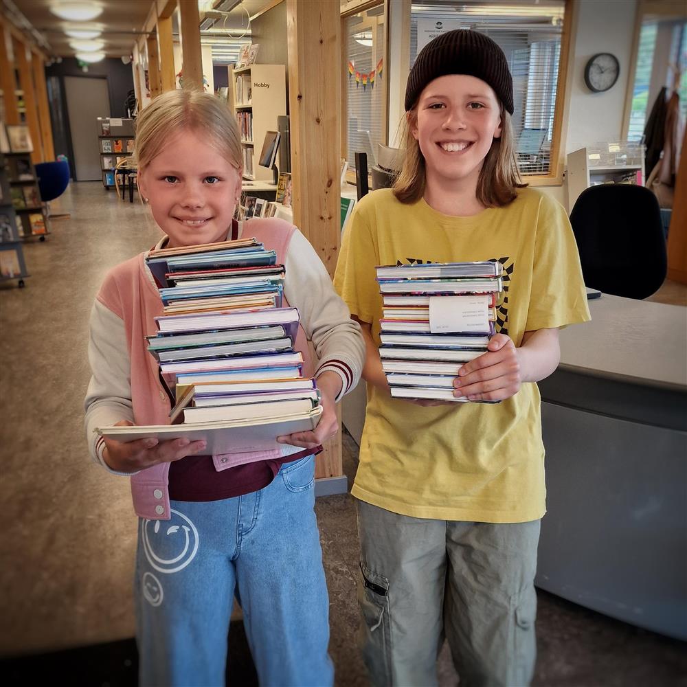 Juni 2025: Konstanse og Alfred har sikra seg bøker til leselystaksjonen "Sommarles - Klikk for stort bilde